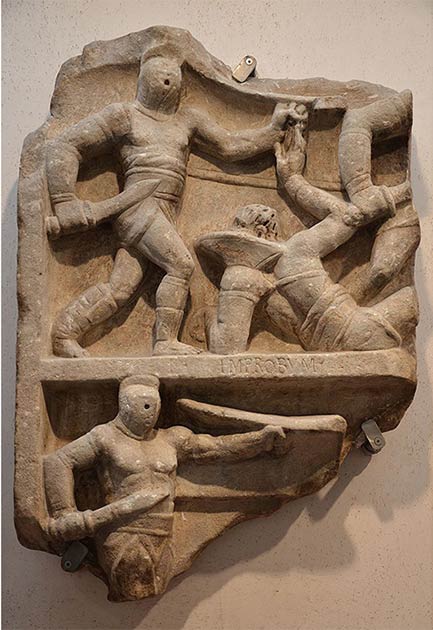 Relief romain montrant des combats de gladiateurs. Sur l'image du haut, un sectateur debout combat un retraité couché sur le sol, tandis qu'en dessous, un autre sectateur est en action. (Suivant Hadrien / CC BY-SA 2.0)
