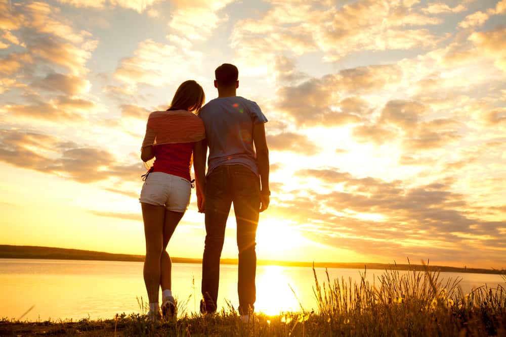 Un jeune couple regarde le coucher de soleil