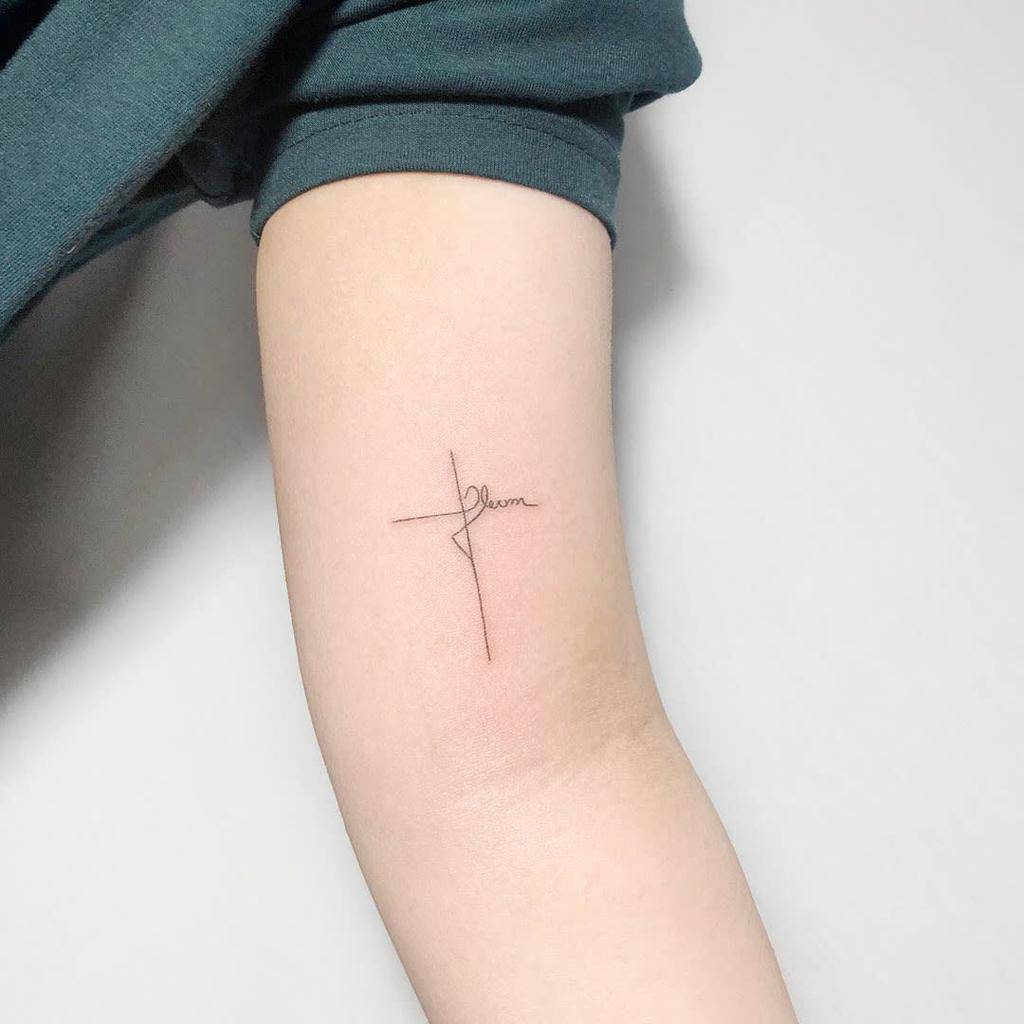 Tatouage de la petite croix au bras supérieur Tatouage de la noul