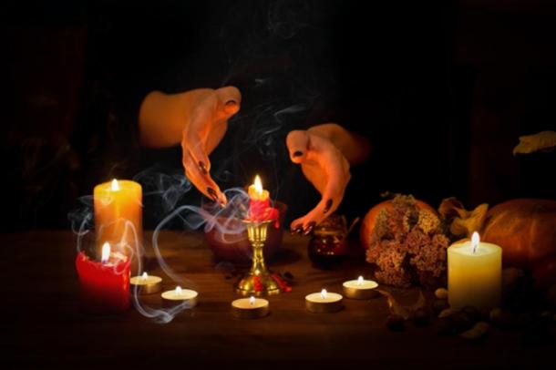 Représentation de la fabrication de sorcières passant sur des bougies et de la cire sur un autel dans l'obscurité. (junky_jess / stock Adobe)