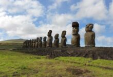 Restored statue platform with standing moai on the south coast of Rapa Nui. Note that one of the moai is adorned with a red scoria pukao.