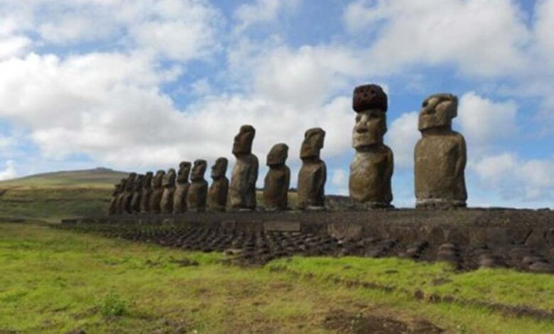Restored statue platform with standing moai on the south coast of Rapa Nui. Note that one of the moai is adorned with a red scoria pukao.